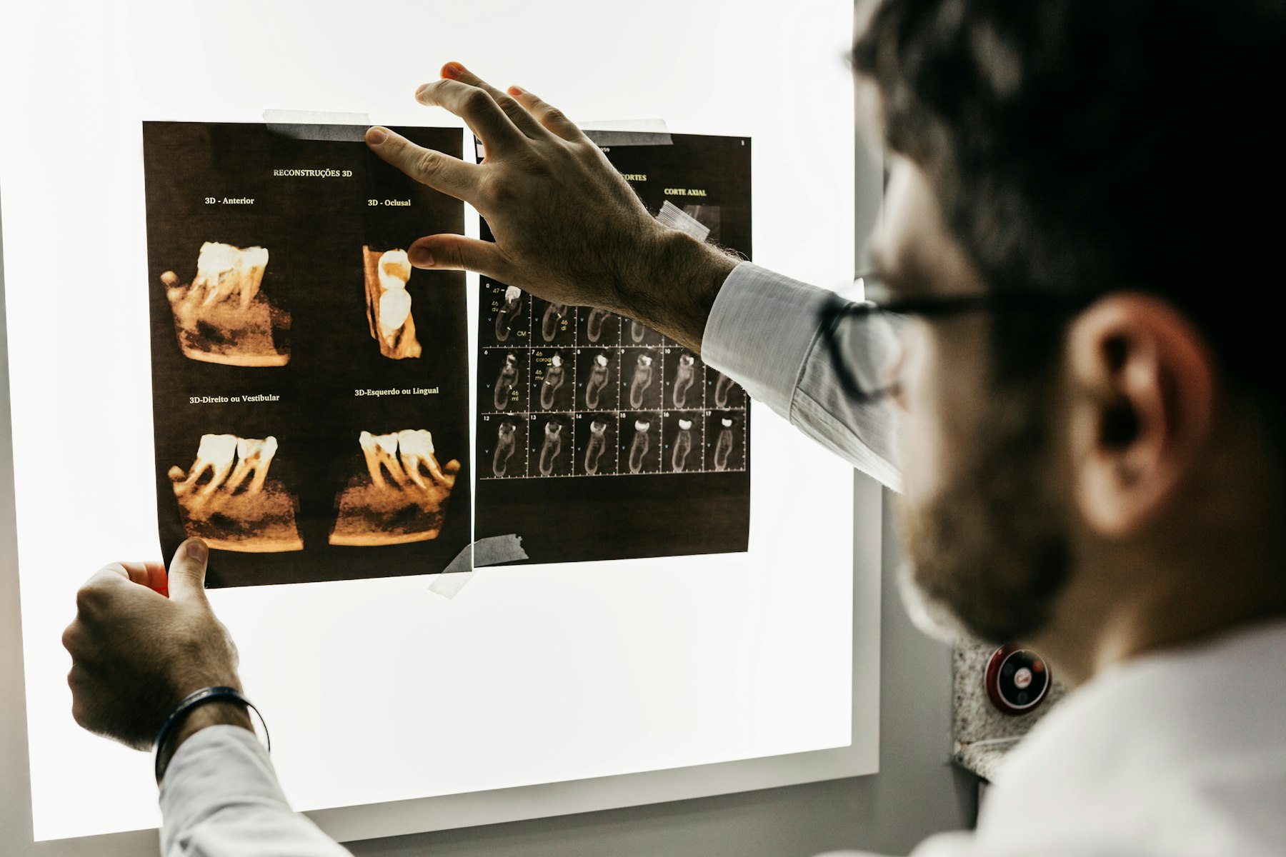 Barn omkring 7 år sitter i tandläkarstol och skrattar mot tandhygienist som håller fram en spegel, färgglada väggar, dagsljus