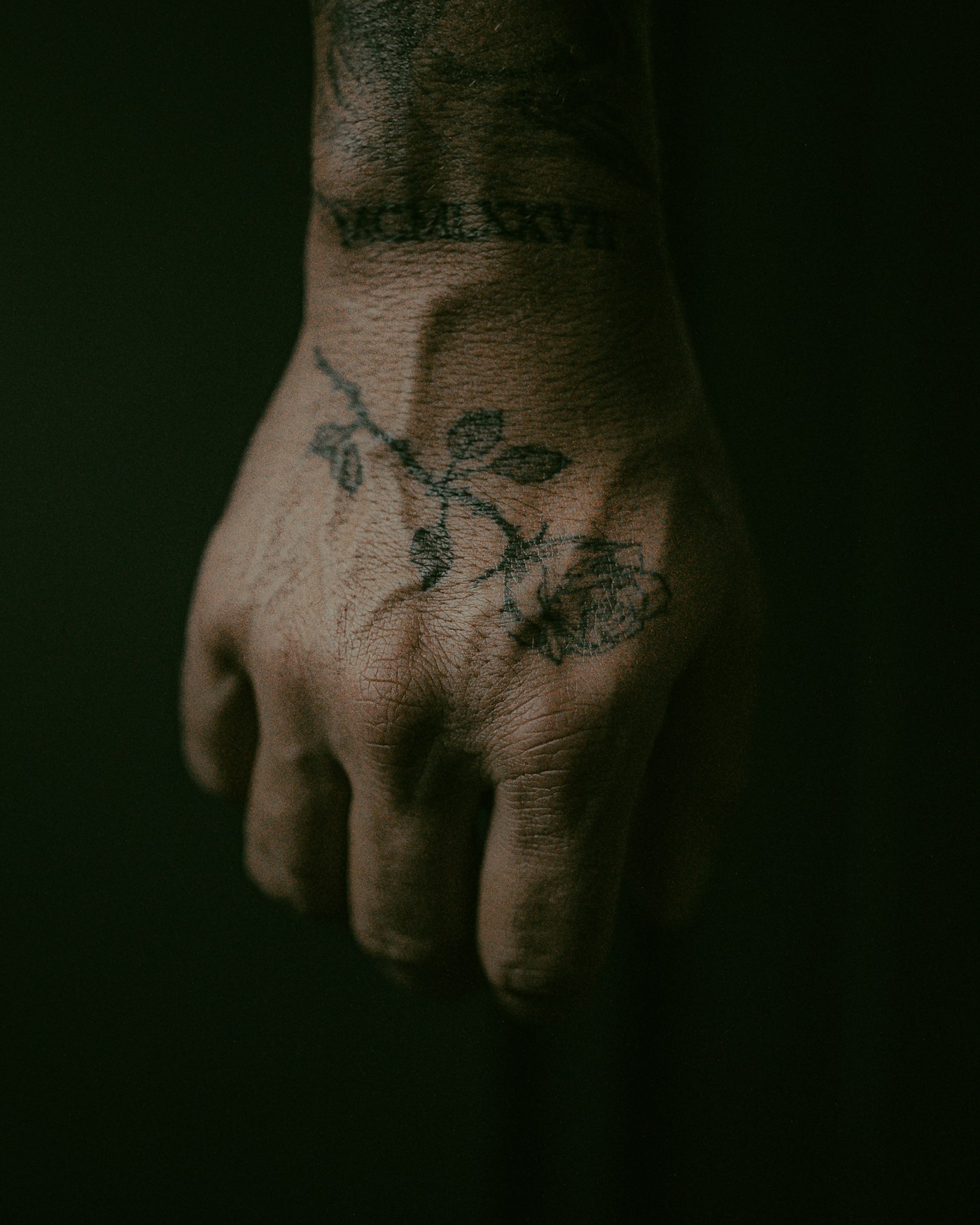 Neotraditional tatuering av en orm lindad runt en dolk på en underarm, djupa färger i rött och grönt
