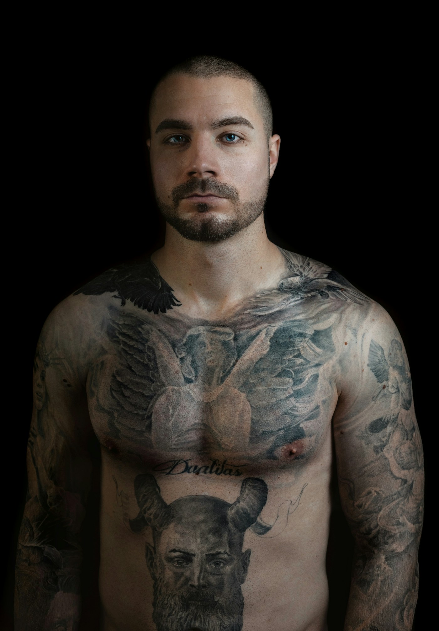 Realistisk porträtttatuering i svartvitt på en axel, mjuka gråtoner och fotografisk detaljnivå